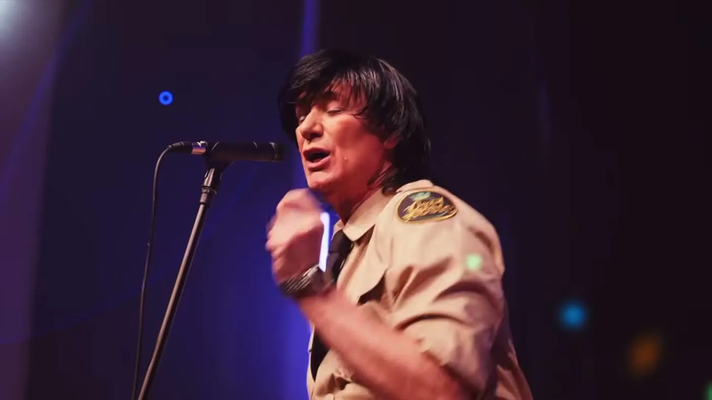 Sam Stevens in a khaki military shirt and black tie
